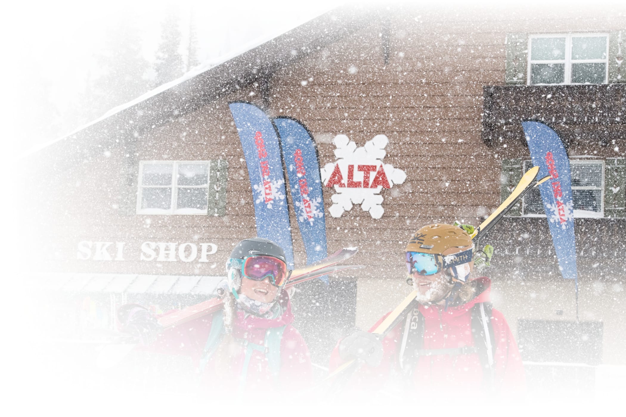 Skiers carrying demo skis out of Alta's Ski Shop on snowy day