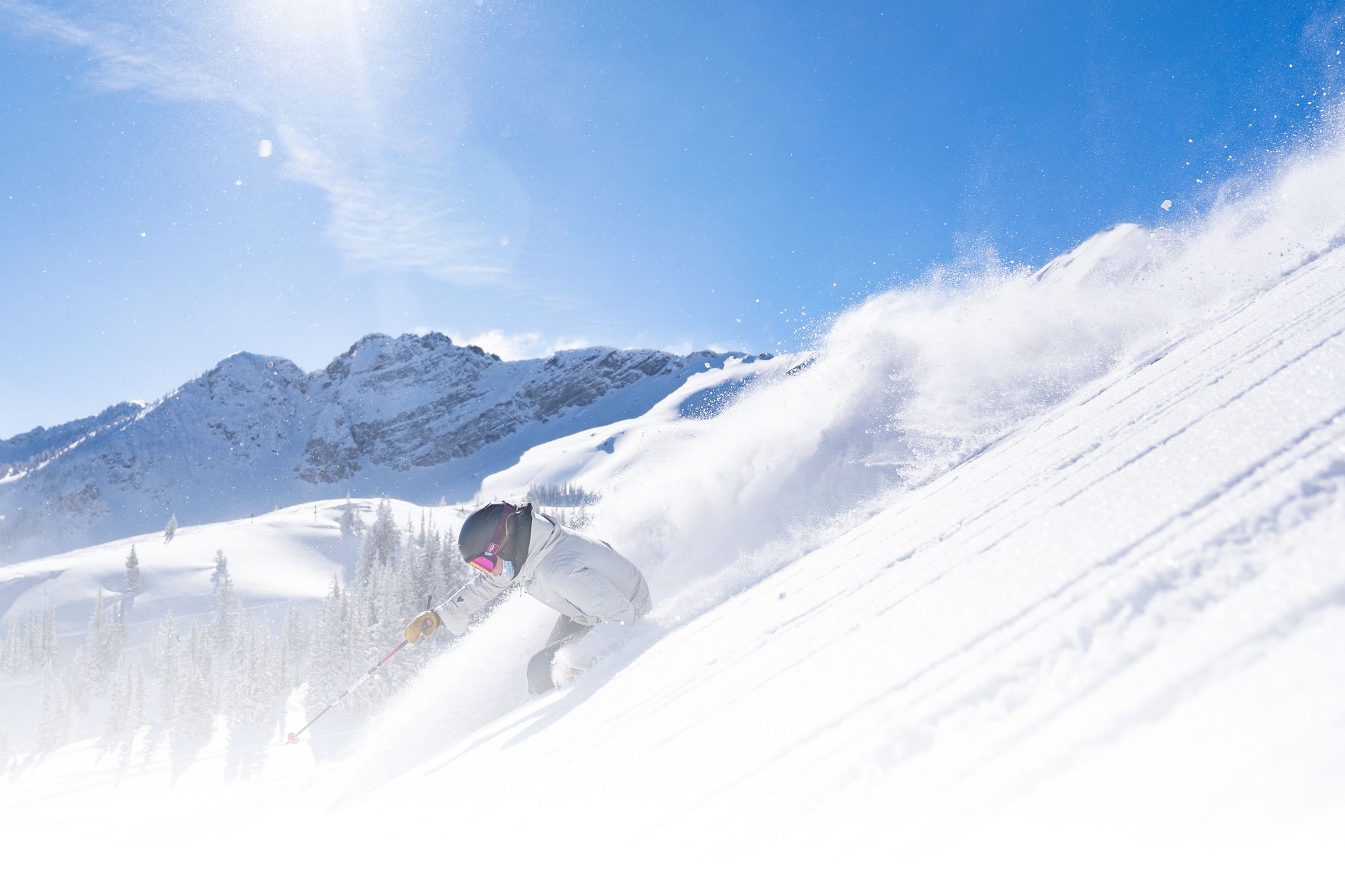 Riley Gibson skiing powder on a bluebird day with Devils Castle in the back.