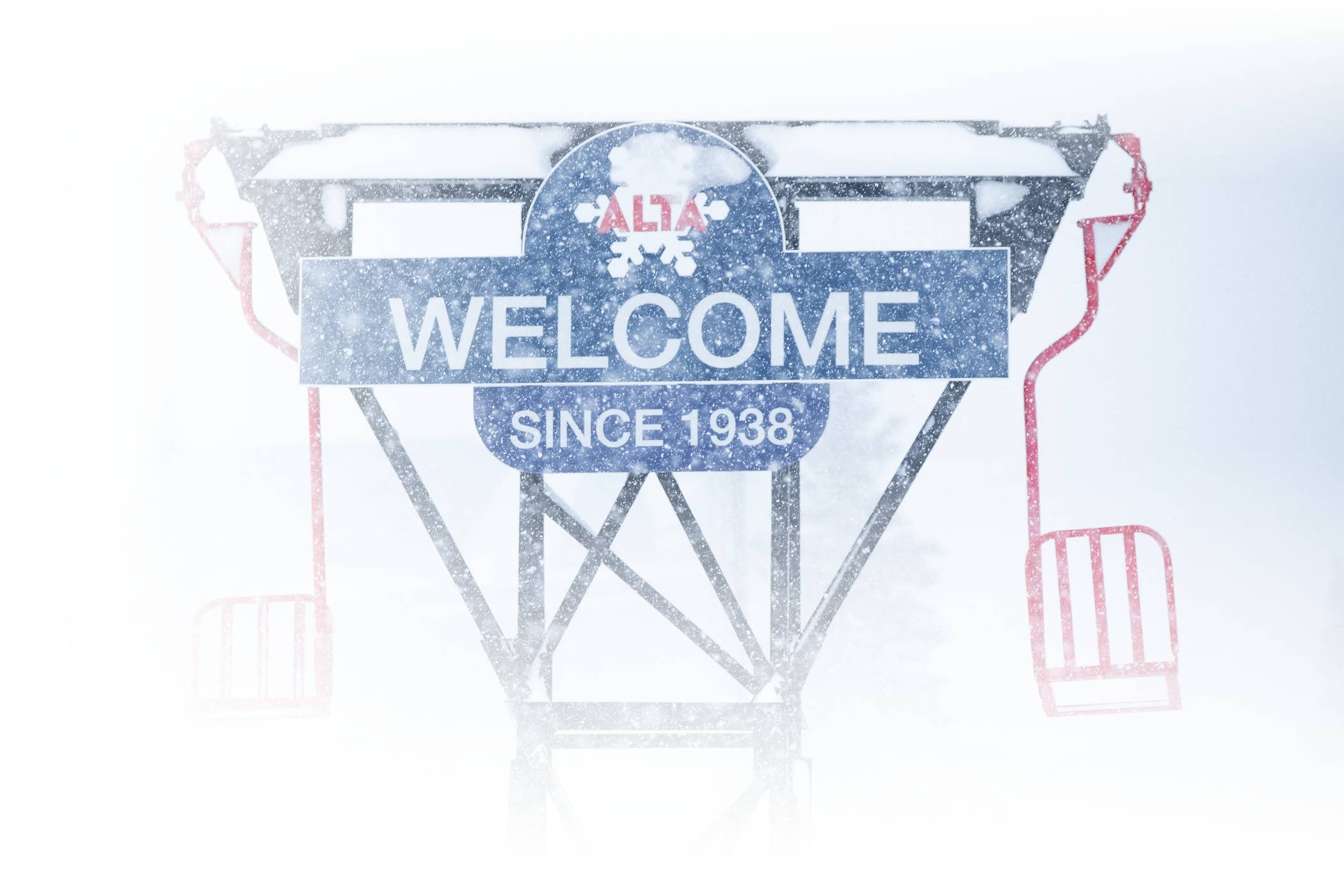 Snow falling on the Welcome to Alta sign